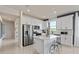 Modern kitchen with white cabinets, stainless steel appliances, and a kitchen island with bar stools at 6324 Dew Drop Loop, St Cloud, FL 34771