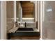 Modern bathroom featuring stone walls, a black sink and wood accents, illuminated by vertical lighting at 6874 Sperone St, Orlando, FL 32819