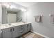 Double vanity bathroom features grey cabinets, neutral towels, and a large mirror at 6874 Sperone St, Orlando, FL 32819