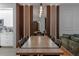 Elegant dining room showcasing a long wood table, modern lighting, and a view into the living area at 6874 Sperone St, Orlando, FL 32819