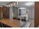 Stylish dining room flowing into a contemporary kitchen, featuring a barn door and modern lighting at 6874 Sperone St, Orlando, FL 32819