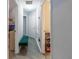 Bright hallway with laminate flooring, a green bench, and white doors offers practical style and function at 6874 Sperone St, Orlando, FL 32819