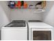 Laundry room features modern washer and dryer with wire shelving above at 6874 Sperone St, Orlando, FL 32819