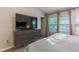 Bright bedroom with large windows and modern dresser with television at 6874 Sperone St, Orlando, FL 32819