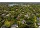 Aerial view of a neighborhood with lush green trees surrounding homes and a lake in the distance at 8368 Rambling River Dr, Sanford, FL 32771