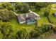 Beautiful aerial view showcasing a lovely home with screened-in pool, manicured lawn, and mature trees at 8368 Rambling River Dr, Sanford, FL 32771