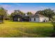 Spacious backyard offers serene outdoor living with a pool, green lawn and mature trees, perfect for recreation at 8368 Rambling River Dr, Sanford, FL 32771