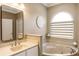 Bathroom with a jacuzzi tub and a white vanity with a mirror at 8368 Rambling River Dr, Sanford, FL 32771