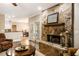 Close up of a stone fireplace with hardwood floors, with kitchen and dining room views at 8368 Rambling River Dr, Sanford, FL 32771