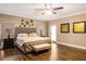 Large main bedroom with ceiling fan, wood floors, tufted headboard and access to a backyard patio at 8368 Rambling River Dr, Sanford, FL 32771