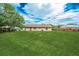 Spacious backyard with a large grass lawn, fence and the back of the house at 855 Third St, Orange City, FL 32763