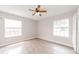 Bedroom with light wood-look floors, two large windows, and ceiling fan at 855 Third St, Orange City, FL 32763