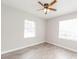 Bedroom with light gray walls, light wood-look flooring, and bright windows with neutral blinds at 855 Third St, Orange City, FL 32763