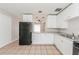 Updated kitchen with white cabinets and a black refrigerator at 855 Third St, Orange City, FL 32763