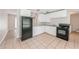 Bright kitchen features white cabinets, tiled floors, and black appliances at 855 Third St, Orange City, FL 32763