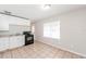 Clean kitchen with white cabinets, a black stove, and tile flooring at 855 Third St, Orange City, FL 32763