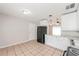 Neutral kitchen with tiled floor, black fridge, and white cabinets at 855 Third St, Orange City, FL 32763