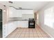 Efficient kitchen with white cabinets, black appliances, and tile floors at 855 Third St, Orange City, FL 32763