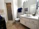 Compact bathroom features white vanity, toilet, and a glass-enclosed shower, enhanced by a neutral tile floor at 8935 Jonathan Manor Dr, Orlando, FL 32819