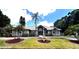 Beautiful single-story home featuring manicured landscaping and a circular driveway with a charming water fountain feature at 8935 Jonathan Manor Dr, Orlando, FL 32819