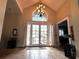 Grand foyer featuring high ceilings, tile flooring, a chandelier, and a double-door entrance with large windows at 8935 Jonathan Manor Dr, Orlando, FL 32819