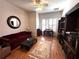 Cozy living area featuring hardwood floors, built-in bookshelves, and a comfortable red sofa near the window at 8935 Jonathan Manor Dr, Orlando, FL 32819