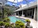 Beautiful in-ground pool in a screened enclosure surrounded by lush landscaping with backyard views at 8935 Jonathan Manor Dr, Orlando, FL 32819
