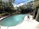 Beautiful in-ground pool in a screened enclosure surrounded by lush landscaping and open sky at 8935 Jonathan Manor Dr, Orlando, FL 32819