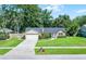 Charming single-story brick home with a well-manicured lawn and mature trees at 1013 Glensprings Ave, Winter Garden, FL 34787