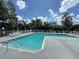 Community pool with lounge chairs and lush foliage at 2608 Grassy Point Dr # 102, Lake Mary, FL 32746