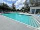 Large community pool with clear blue water, lounge seating, landscaping, and laundry room at 2608 Grassy Point Dr # 102, Lake Mary, FL 32746