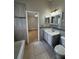 A tiled bathroom featuring a tub, toilet, vanity with sink, decorative mirror, and access to the bedroom at 330 Sweetwater Springs St, Debary, FL 32713