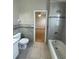 A tiled bathroom featuring a tub, toilet, and access to the bedroom with a ceiling fan at 330 Sweetwater Springs St, Debary, FL 32713