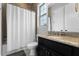 Bathroom featuring a shower-tub combo with white shower curtain and dark vanity with countertop at 3863 Grassland Loop, Lake Mary, FL 32746