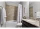 Bathroom showcasing a shower-tub combo, tile surround, and stylish vanity with granite countertop at 3863 Grassland Loop, Lake Mary, FL 32746