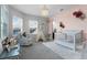 Charming Bedroom with rocking chair, decorative floral accents, white crib, and ample natural light at 3863 Grassland Loop, Lake Mary, FL 32746