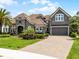 Elegant home with a tile roof, manicured lawn, paver driveway and two car garage at 3863 Grassland Loop, Lake Mary, FL 32746