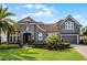 Imposing two-story home with lush landscaping, a paver driveway and a two car garage at 3863 Grassland Loop, Lake Mary, FL 32746