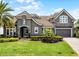Beautiful two-story home with a well-manicured lawn, lush landscaping, and a gray exterior at 3863 Grassland Loop, Lake Mary, FL 32746