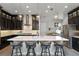 Modern kitchen with a large center island, pendant lighting, dark cabinets, and stainless steel appliances at 3863 Grassland Loop, Lake Mary, FL 32746