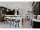 Modern kitchen with a large center island, pendant lighting, dark cabinets, and stainless steel appliances at 3863 Grassland Loop, Lake Mary, FL 32746