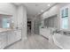 Bright main bathroom featuring a soaking tub, dual vanities, and a walk-in shower at 3863 Grassland Loop, Lake Mary, FL 32746