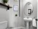 Cozy powder room with pedestal sink, and a decorative mirror at 3863 Grassland Loop, Lake Mary, FL 32746