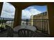 A cozy condo balcony featuring a table and chairs with a scenic view of the resort and landscaped grounds at 8125 Resort Village Dr # 51006, Orlando, FL 32821