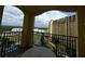 Relaxing condo balcony with seating and scenic views overlooking lush grounds, a pool, and a neighboring building at 8125 Resort Village Dr # 51006, Orlando, FL 32821