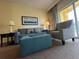 Relaxing living room showcases a plush sofa, houndstooth armchair, lamps, and large picture window at 8125 Resort Village Dr # 51006, Orlando, FL 32821