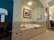 Bright bathroom with a soaking tub with tile surround and a glass enclosed shower at 8125 Resort Village Dr # 51006, Orlando, FL 32821