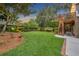 Spacious backyard with lush green lawn, mature trees, and a swing set at 1299 Harding Street, Winter Park, FL 32789