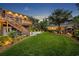 Expansive backyard featuring lush green grass, a wooden deck, and meticulous landscaping at 1299 Harding Street, Winter Park, FL 32789