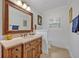 Bathroom with vanity, decorative mirror, travertine floors and tiled shower at 1299 Harding Street, Winter Park, FL 32789